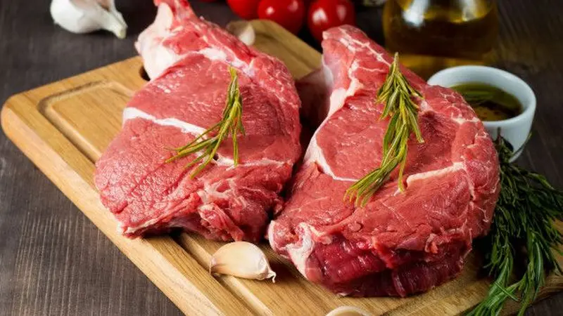 Masakan daging yang dipanaskan ulang dalam wadah plastik di atas kompor